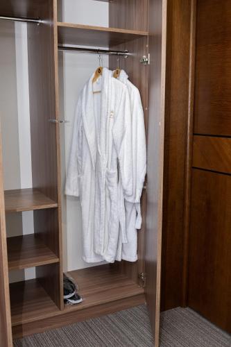 a closet with white clothes hanging in it at Pava De Luxe in Berehove