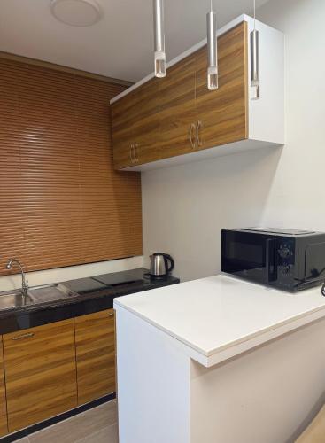 a kitchen with a white counter and a microwave at Solumie Boutique Hotel in Bangkok