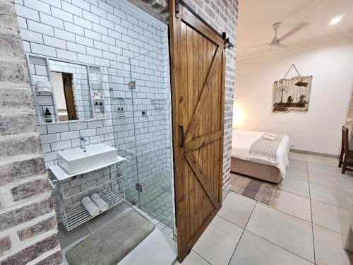 a bathroom with a glass shower and a sink at Leopard Tree Lodge in St Lucia