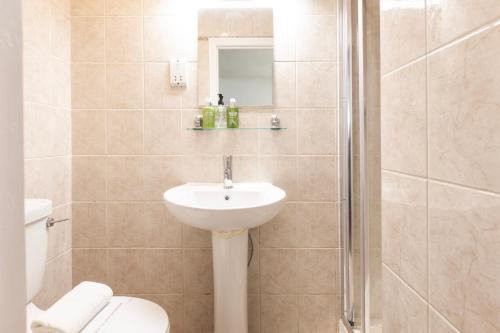 a bathroom with a sink and a toilet and a shower at Magic Stay Rooms in London