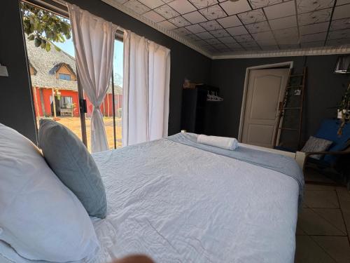 a large bed in a bedroom with a window at Buckswood Hilltops in Stegi