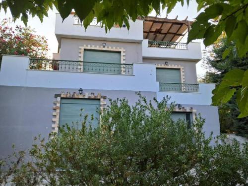 a white building with balconies on the side of it at Aylida House in Paralía Avlídhos