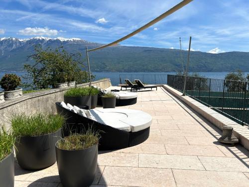 a patio with a view of the water and mountains at Hotel Villa Giulia in Gargnano