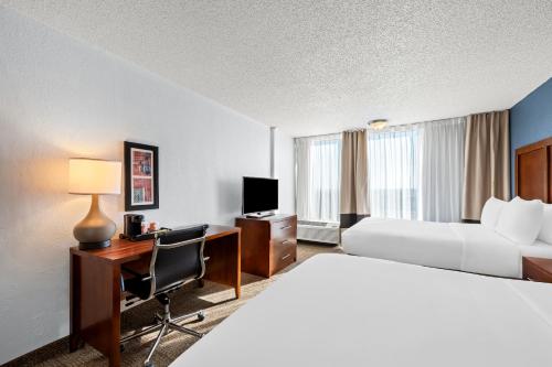 a hotel room with a bed and a desk with a computer at Comfort Inn & Suites Omaha Central in Omaha