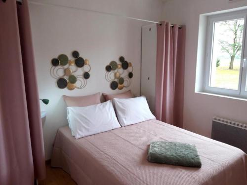 una camera da letto con un letto con una coperta rosa e una finestra di Gite de la teoulere a Bas-Mauco
