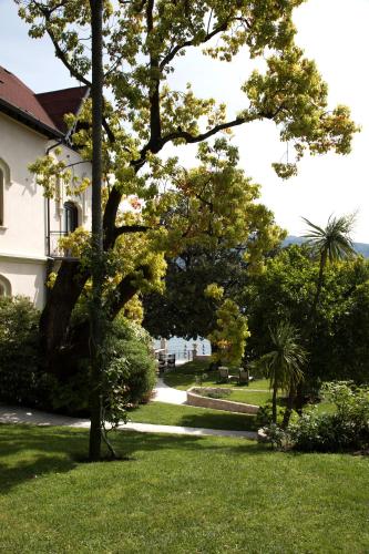 a house with a tree in the yard at Hotel Villa Giulia in Gargnano