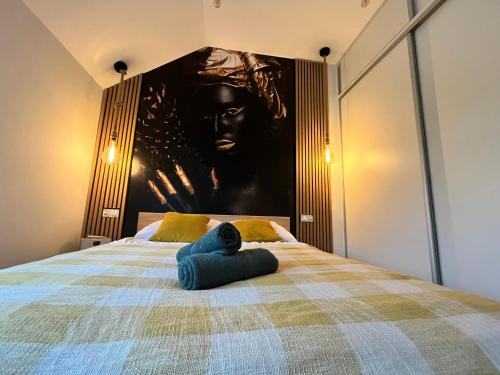 a bedroom with a bed with a large painting on the wall at Apartment Roku 2024 - JELEŃ & NATURA in Kudowa-Zdrój