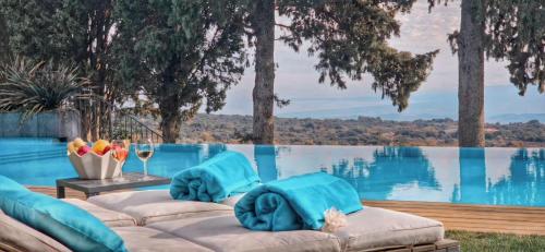 a pool with lounge chairs and a view of the water at Rahal Luxury- Panoramic Hot tub & Infinity Pool in Catania