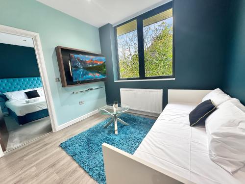 a bedroom with a white bed and a tv at Clyde Inn in Milton Keynes