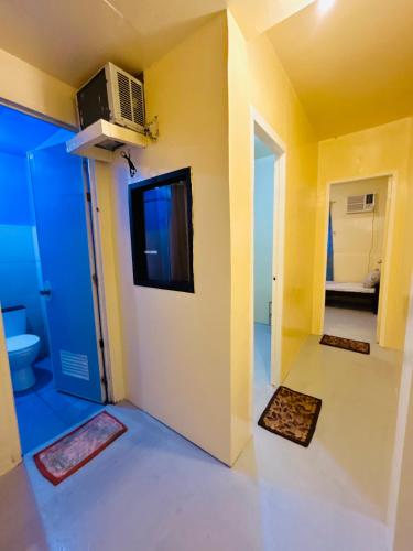 a room with a yellow wall and a bathroom at Daltans Home Stay Siargao in General Luna