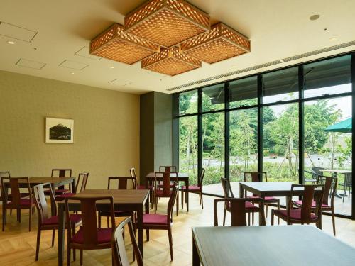 a dining room with tables and chairs and windows at Mitsui Garden Hotel Kashiwa-no-ha Park Side - Chiba in Kashiwa