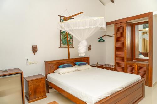 a bedroom with a bed and a window at Piyum villa in Weligama