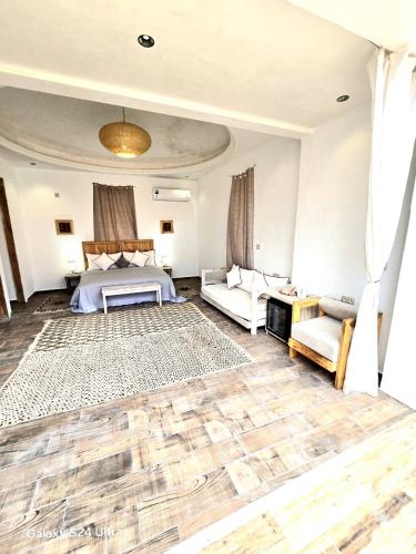 a bedroom with a bed and a couch and a table at Villa A'Kabar Guest House in Tamdakht