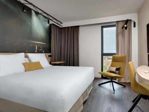 a bedroom with a white bed and a desk and a sink at Mercure Montpellier Centre Comédie in Montpellier