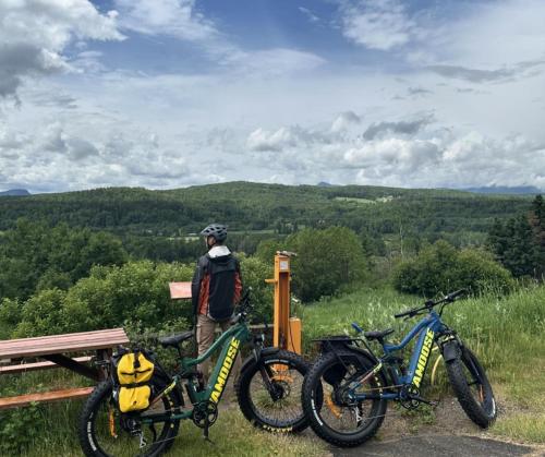 a man standing next to two bikes on a hill at Hebergement du grenier 2 0 in Notre-Dame-des-Monts