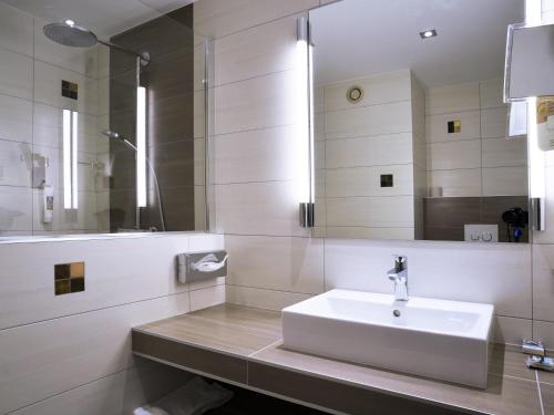 a bathroom with a sink and a mirror at Mercure Montpellier Centre Comédie in Montpellier