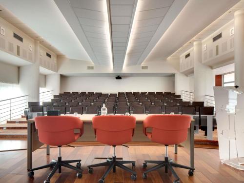 an empty conference room with a table and chairs at Mercure Montpellier Centre Comédie in Montpellier