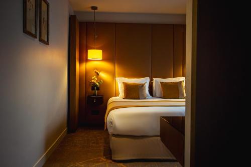 a hotel room with a bed with a headboard at Hôtel La Bourdonnais by Inwood Hotels in Paris