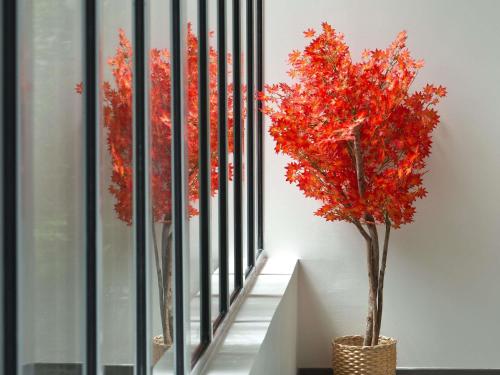 two trees in vases next to a stair railing at Mercure Montpellier Centre Comédie in Montpellier
