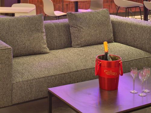 a couch with a table with a can of wine at Mercure Montpellier Centre Comédie in Montpellier