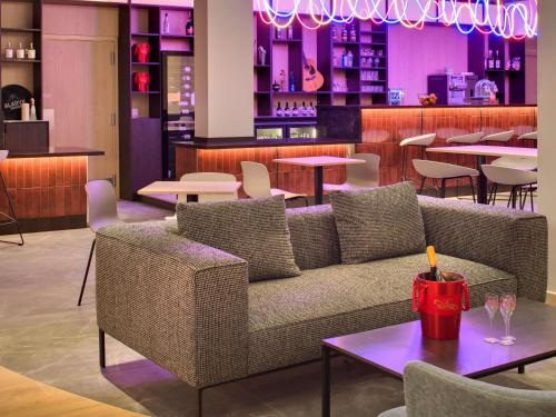 a living room with a couch and tables and a bar at Mercure Montpellier Centre Comédie in Montpellier
