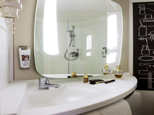 a bathroom with a sink and a mirror at ibis Amsterdam Centre Stopera in Amsterdam
