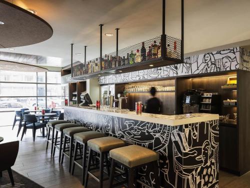 a restaurant with a bar with stools at ibis Amsterdam Centre Stopera in Amsterdam