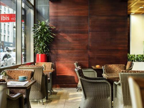 a restaurant with wooden walls and tables and chairs at ibis Wellington in Wellington