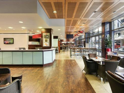 a restaurant with a bar and tables and chairs at ibis Wellington in Wellington
