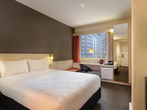 a hotel room with a large bed and a bathroom at ibis Wellington in Wellington