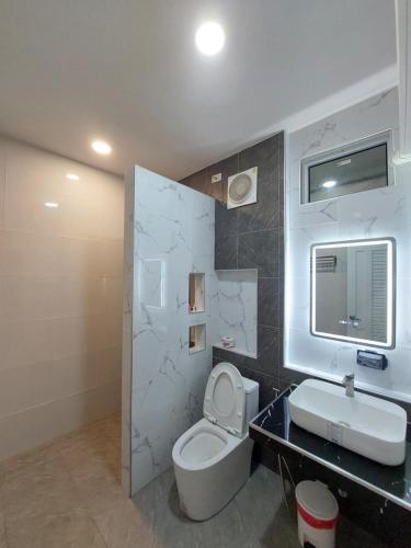 a bathroom with a white toilet and a sink at J House Has love in Sukhothai