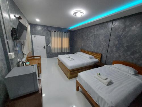 a hotel room with two beds and a bathroom at J House Has love in Sukhothai