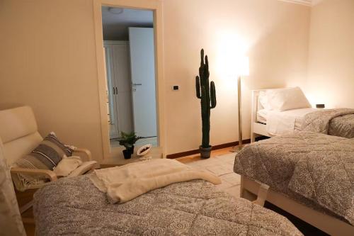 a bedroom with two beds and a chair and a mirror at Country House, on the slopes of Vesuvius 3 in Terzigno