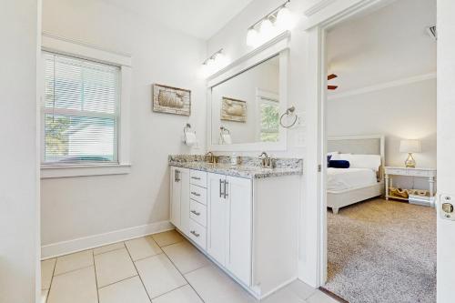 a bathroom with a sink and a mirror and a bed at Grande Pointe Driftwood in Inlet Beach