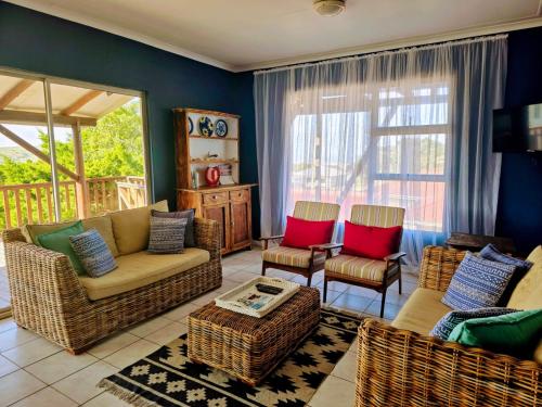 a living room with wicker chairs and a couch at The Kei Mouth Guest Lodge Collection in Kei-mouth Village