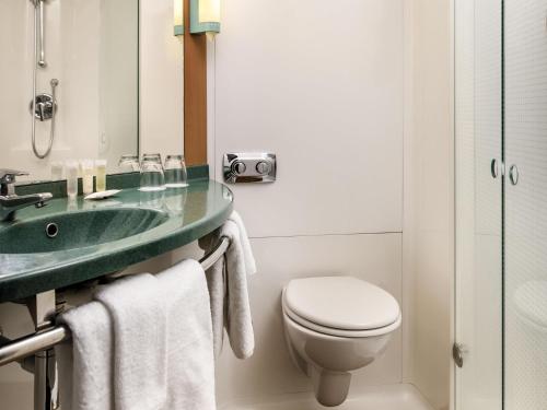 a bathroom with a toilet and a sink at ibis Auckland Ellerslie in Auckland