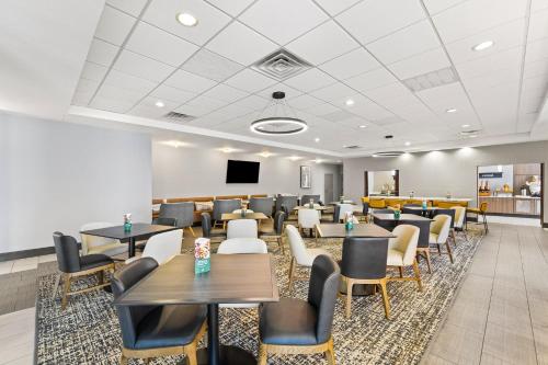 a dining room with tables and chairs and a flat screen tv at Holiday Inn Austin North by IHG in Round Rock
