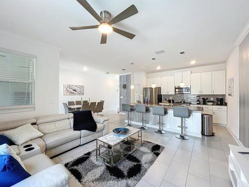 a living room with a couch and a ceiling fan at Luxury Pool Home Near Disney Resort Access in Kissimmee