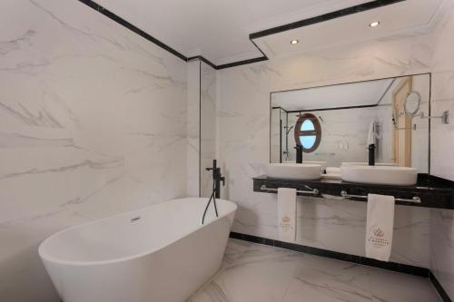 a white bathroom with two sinks and a tub at Eugenia de Montijo, Autograph Collection in Toledo