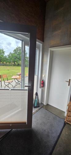 an empty room with a door and a balcony at Ferienhaus LODA - Garten, Netflix & Spreewald Flair in Heinersbrück
