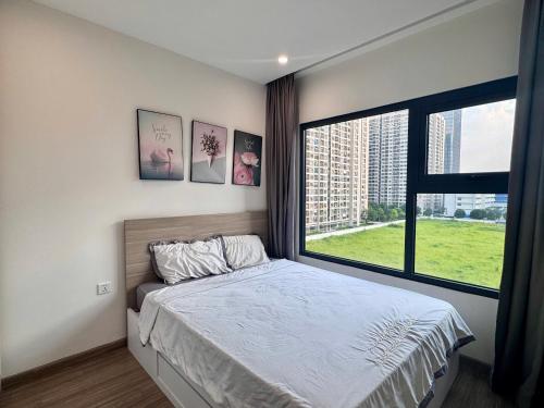 Un dormitorio con una cama y una ventana grande. en Sora House 8 - Vinhomes Ocean Park, en Gia Lâm Pho