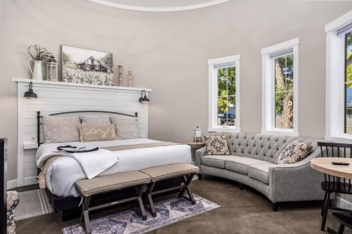 a bedroom with a bed and a couch and windows at Silo Suite 2-Near Zion National Park in La Verkin