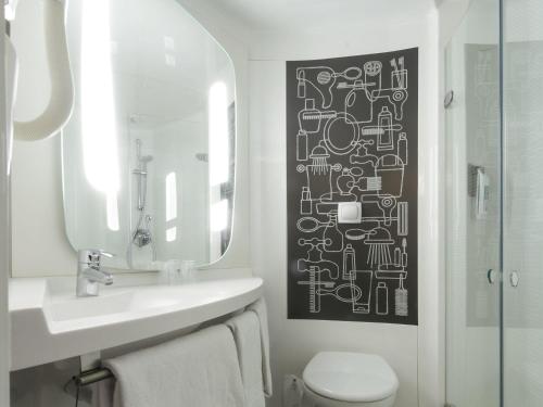 a bathroom with a sink and a mirror and a toilet at ibis London Stratford in London
