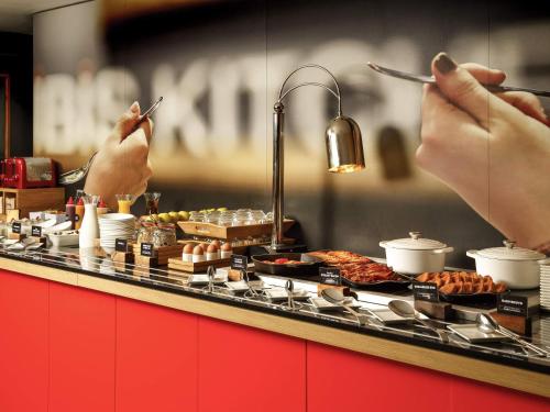 a buffet line with food on top at ibis London Stratford in London