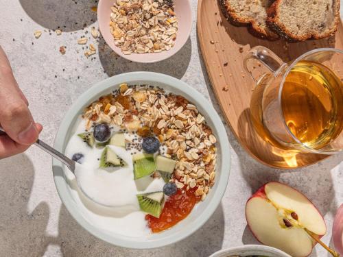 a bowl of yogurt with fruit and a bowl of nuts at ibis London Stratford in London
