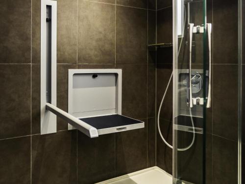 a bathroom with a shower with a glass door at Novotel London Tower Bridge in London