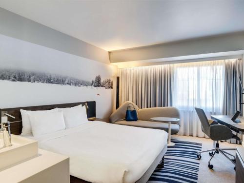 a hotel room with a bed and a desk at Novotel London Tower Bridge in London