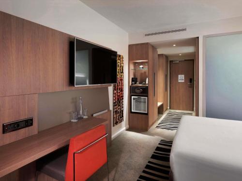 a room with a bed and a television in a room at Novotel London Tower Bridge in London