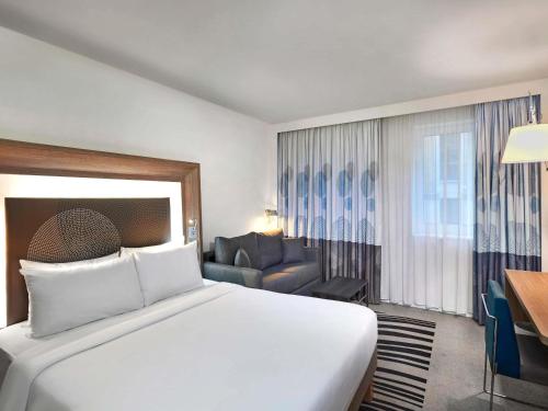 a hotel room with a large bed and a couch at Novotel London Tower Bridge in London