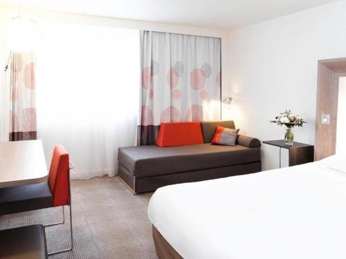 a hotel room with a bed and a couch at Novotel London Tower Bridge in London